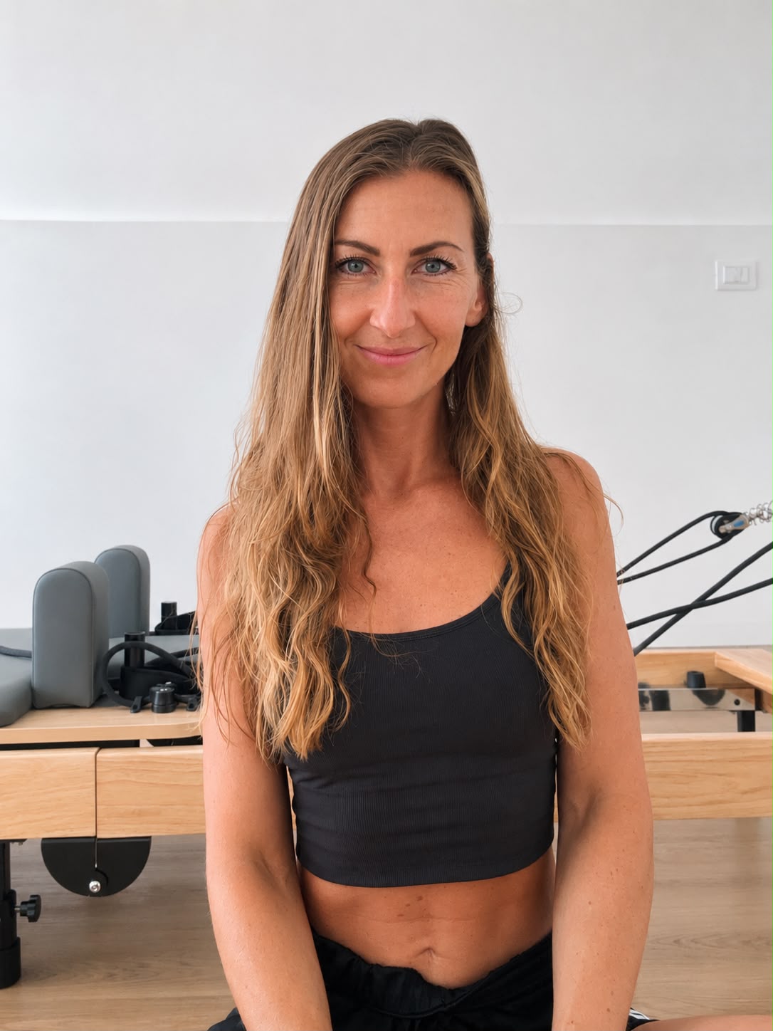 Istruttrice di Pilates nello studio Feel Good con reformer sullo sfondo